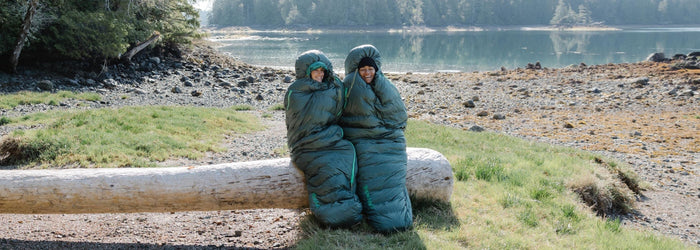 To glade hikers siddende i deres soveposer