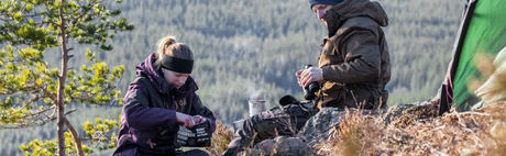 personer tilbereder feltrationer i naturen 