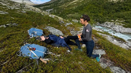 Kvinde udøver førstehjælp i naturen 