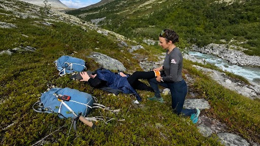 Kvinde udøver førstehjælp i naturen 